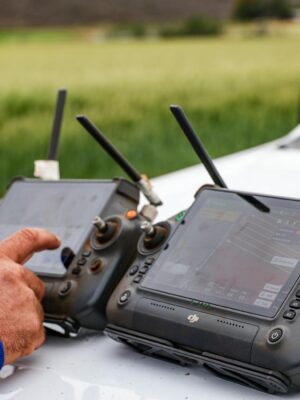 Close-up of farmers using drone controllers on a farm for precision agriculture.