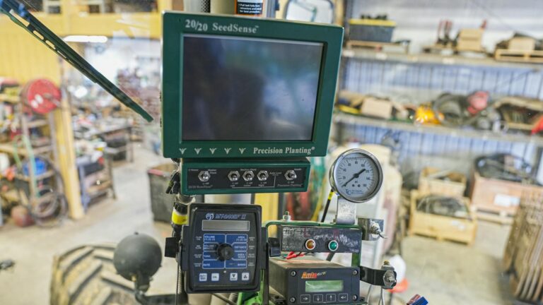 Close-up of SeedSense precision planting device in agricultural workshop, showcasing modern farming technology.