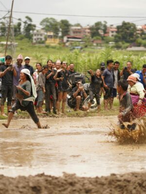Energetic mud race with vibrant locals celebrating in rural Nepal.