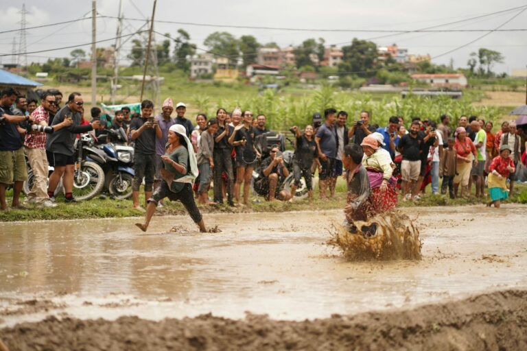 Energetic mud race with vibrant locals celebrating in rural Nepal.